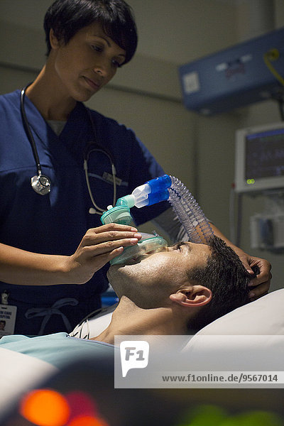 Ärztin mit Maske Anästhesierender Mann im Krankenhaus