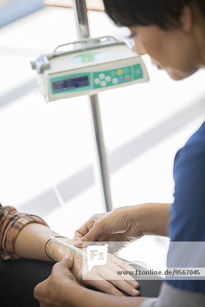 Arzt, der dem Patienten eine intravenöse Infusion verabreicht