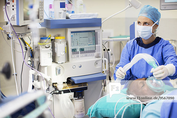 Ärztin in OP-Kleidung Anästhesiepatientin im Operationssaal