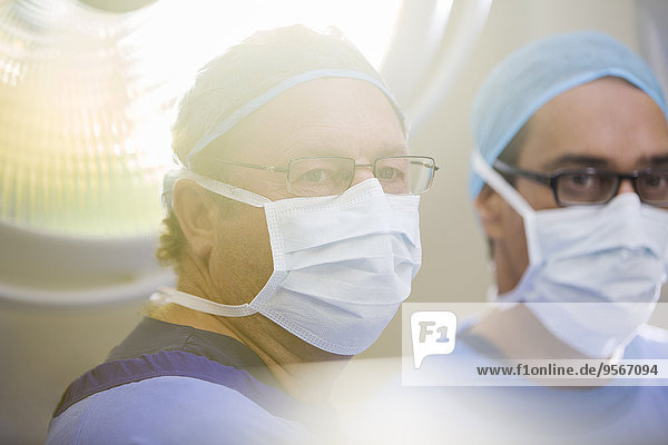 Portrait of two doctors wearing surgical caps  masks and glasses in operating theater