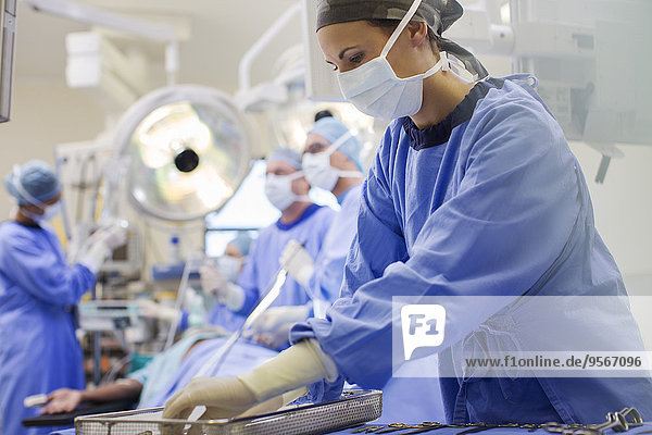 Krankenschwester mit Peelings zur Vorbereitung medizinischer Instrumente im Operationssaal