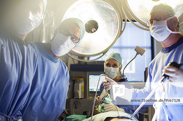 Team of doctors performing laparoscopic surgery in operating theater