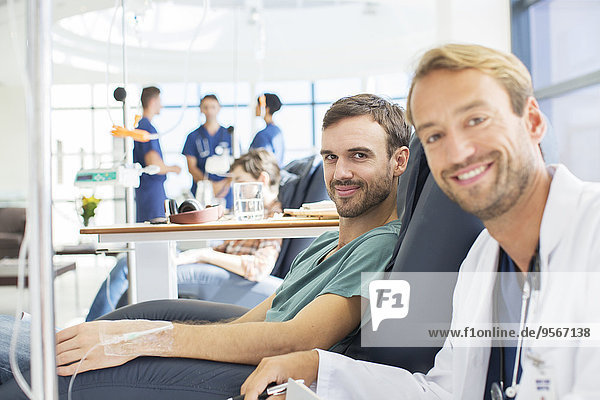 Porträt des lächelnden Arztes und Patienten in der Ambulanz