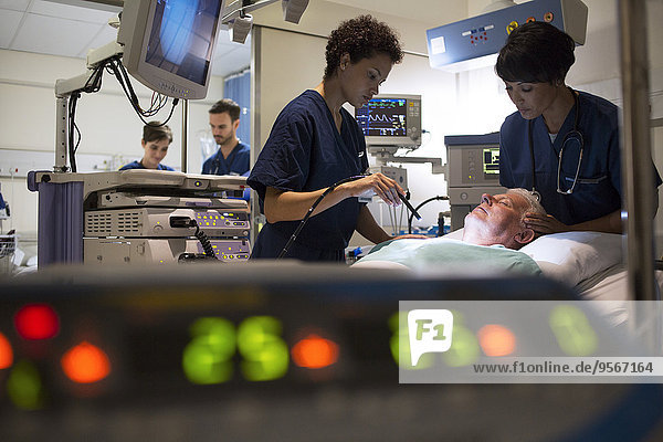 Doctors attending patient in intensive care unit  monitoring equipment in foreground