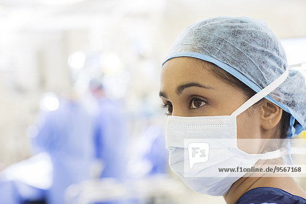 Portrait of surgical nurse wearing surgical cap and mask in operating theater