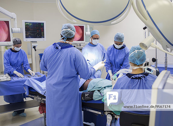 Team of doctors performing surgery in operating theater