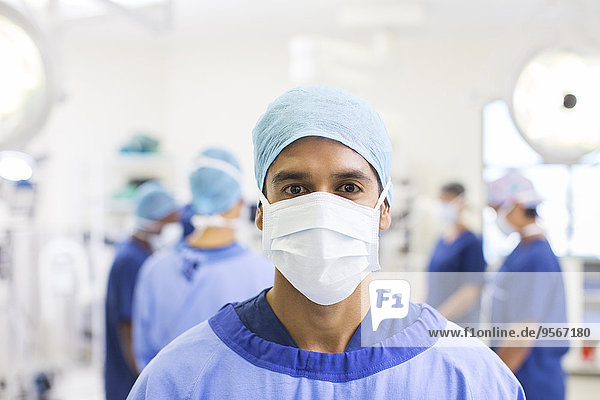 Portrait of surgeon wearing surgical cap  mask and gown in operating theater
