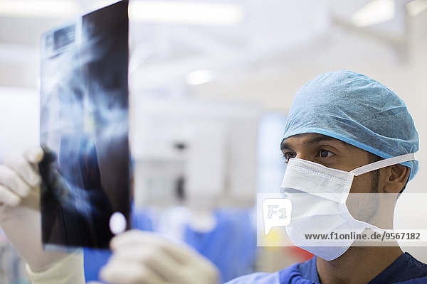 Nahaufnahme des Chirurgen mit OP-Kappe und Maske beim Röntgen im Operationssaal