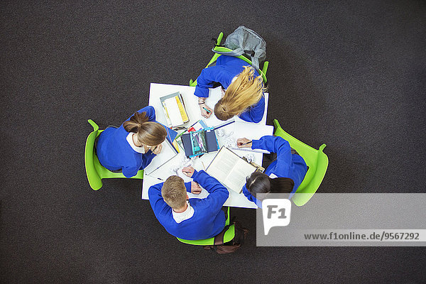 Overhead-Ansicht der Schüler,  die gemeinsam ihre Hausaufgaben machen