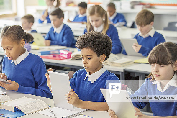 Grundschulkinder mit digitalen Tabletten im Klassenzimmer