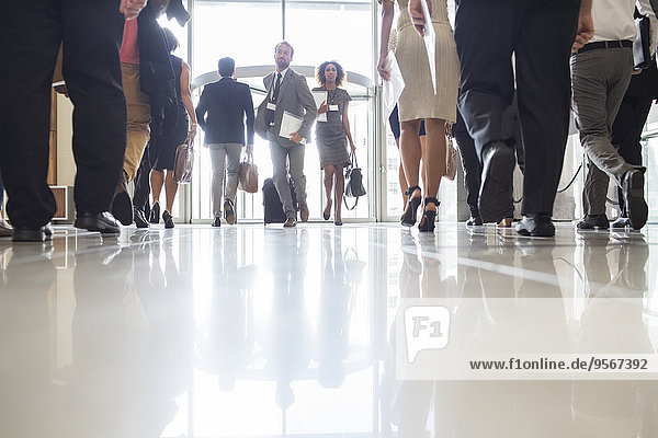 Business people rushing through office hall  reflections on tiled floor