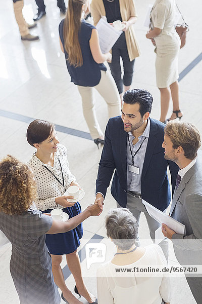 High angle view of group of business people shaking hands in office