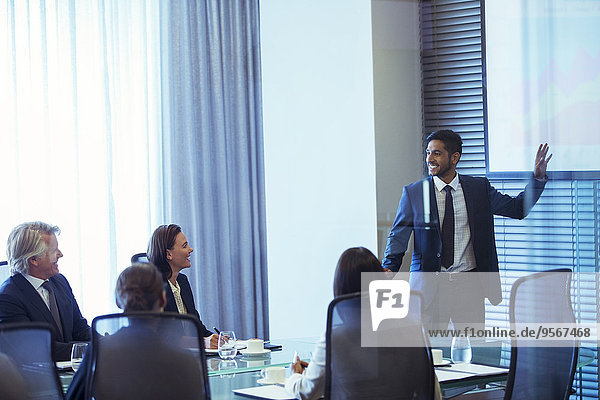 Businessman giving presentation to colleagues in conference room