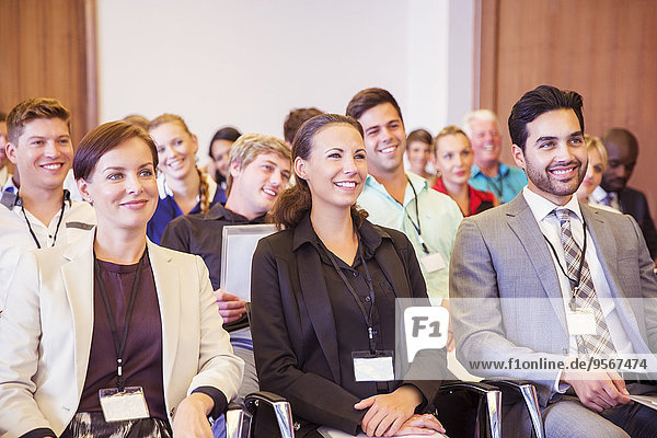 Geschäftsleute  die im Konferenzraum sitzen  lächeln und wegschauen