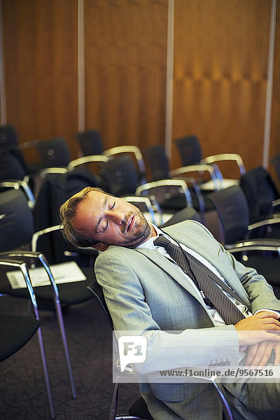 Geschäftsmann schläft im Konferenzraum