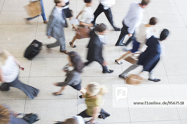 High angle view of business people walking in office on tiled floor