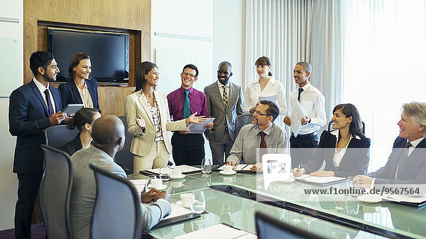 Businesswoman standing at head of conference table and talking