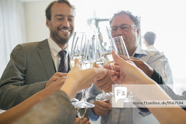 Geschäftsleute stoßen während des Meetings mit Champagner an.