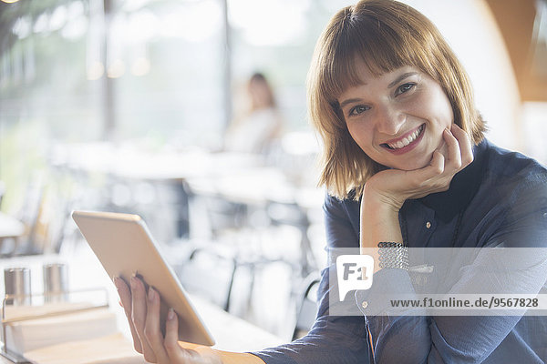 Geschäftsfrau mit digitalem Tablett in der Cafeteria
