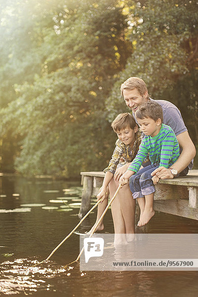 Father and sons fishing in lake