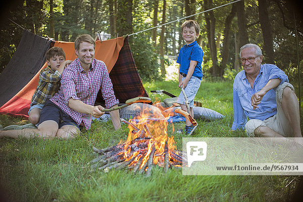 Junge  Vater und Großvater entspannen am Lagerfeuer