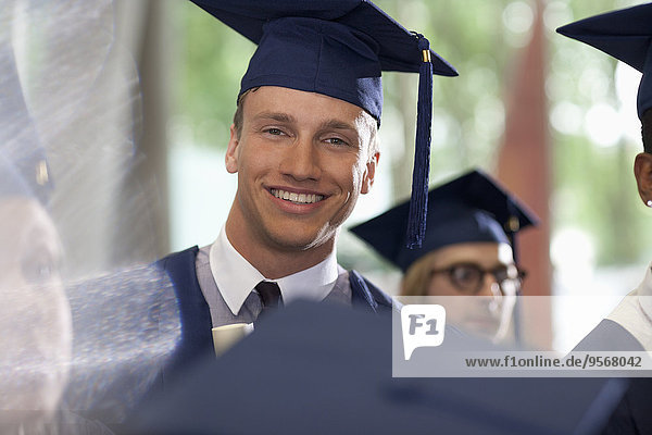 Porträt eines lächelnden Studenten bei der Abschlussfeier
