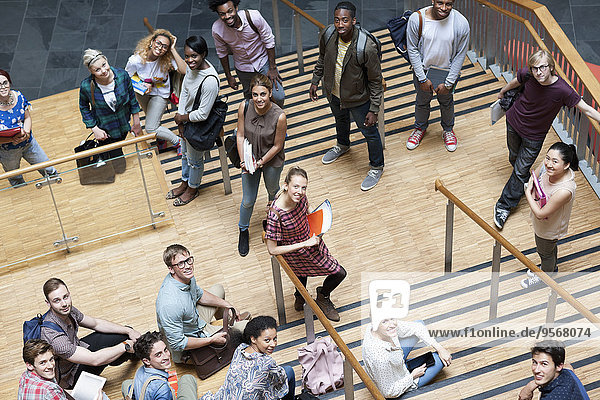 Portrait of university students standing together on staircase