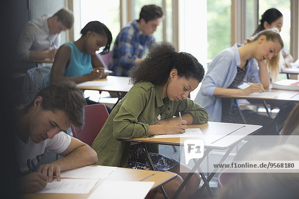 View of students sitting at desks during test in classroom
