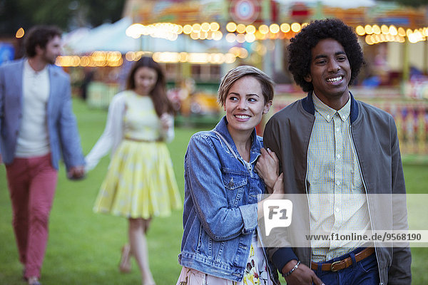 Junges gemischtrassiges Paar lächelt beim Spaziergang im Vergnügungspark