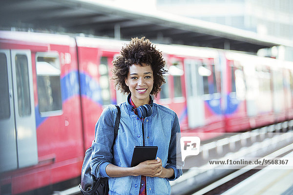 Lächelnde Frau im Bahnhof stehend