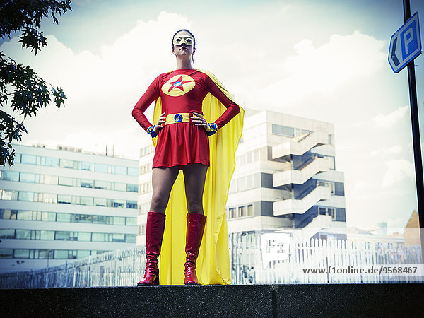 Superheld stehend mit den Händen auf den Hüften in der Stadt