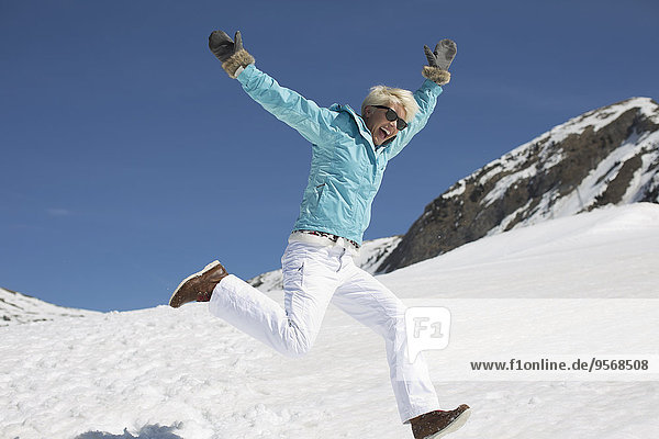 Exuberant woman playing in snow