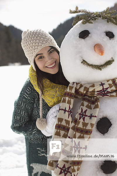 Portrait of smiling woman with snowman