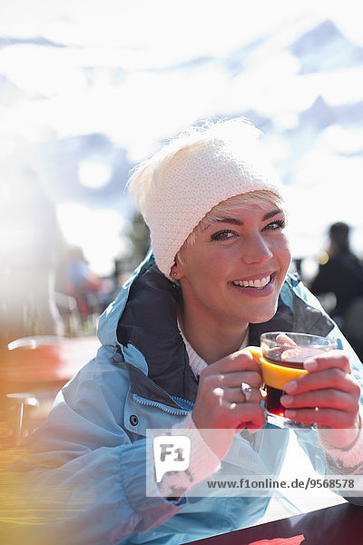 Portrait of smiling woman in warm clothing drinking tea