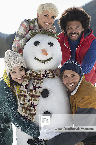 Portrait of friends with snowman