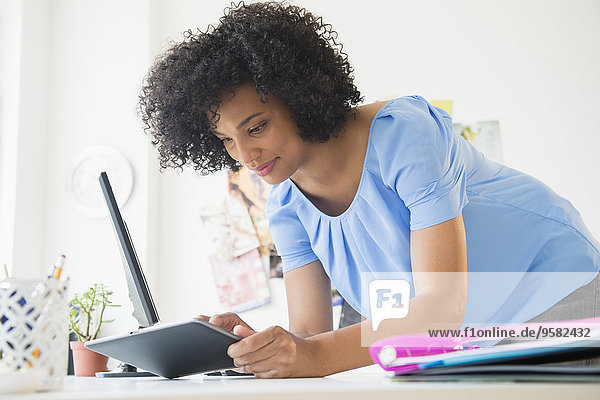 Woman using digital tablet on desk