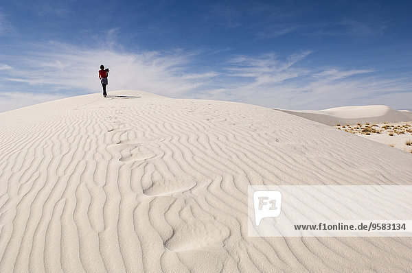 Man climbing sand dune in desert