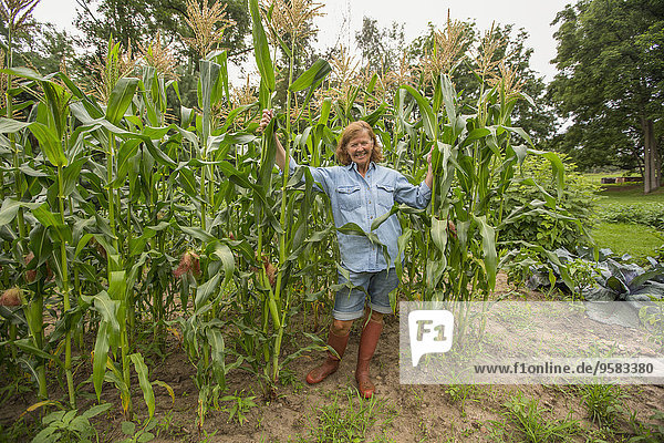 Older Caucasian woman standing in corn field on farm