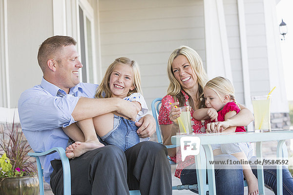Caucasian family sitting on porch