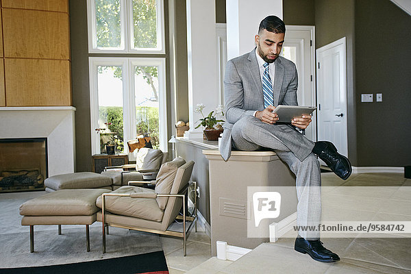 Middle Eastern businessman using digital tablet at home
