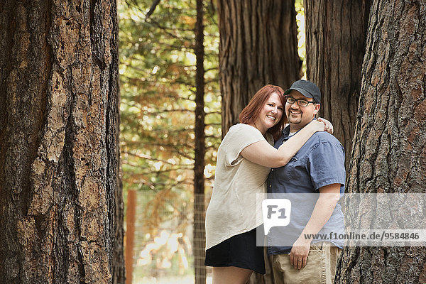 Caucasian couple hugging in forest