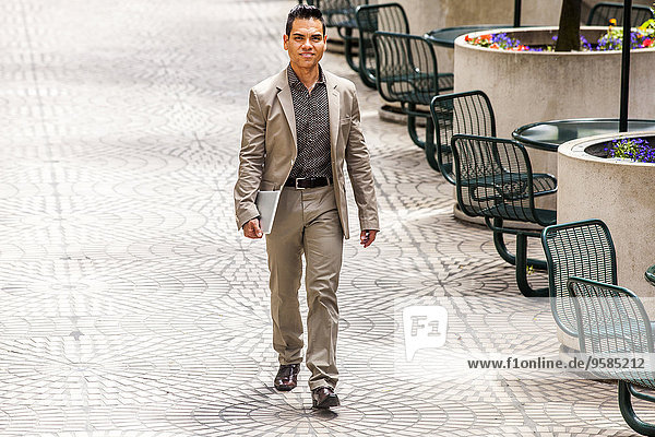 Hispanic businessman walking in courtyard
