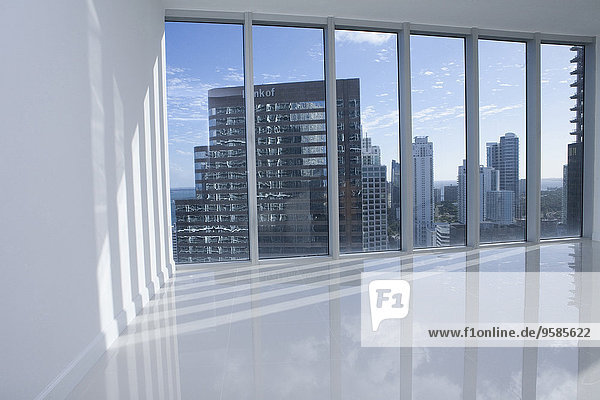 Windows overlooking cityscape in empty modern apartment