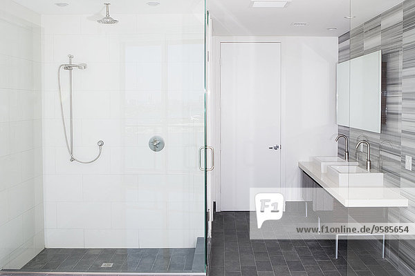 Shower  sinks and mirror in modern bathroom