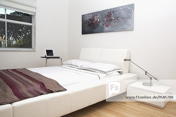 Bed  wall art and night tables in modern bedroom