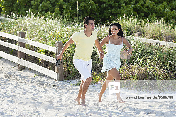 Hispanic couple walking on beach
