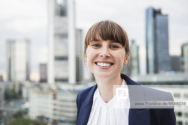 Germany  Hesse  Frankfurt  portrait of smiling businesswoman in front of skyline