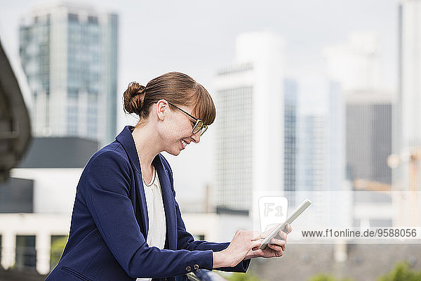 Deutschland  Hessen  Frankfurt  lächelnde Geschäftsfrau mit ihrem digitalen Tablett
