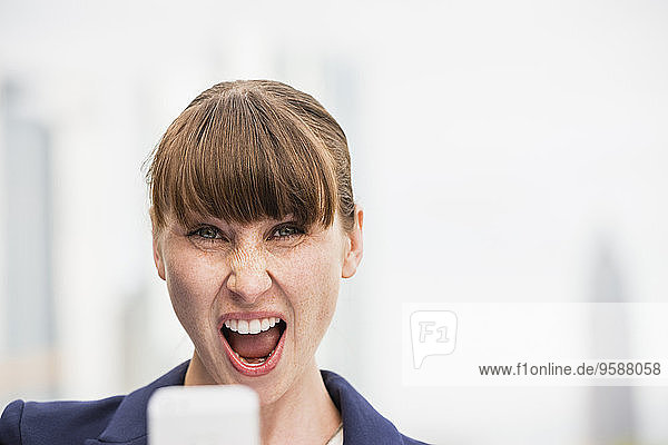 Portrait of screaming businesswoman with smartphone