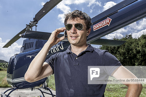 Germany  Bavaria  Landshut  Helicopter pilot using mobile phone